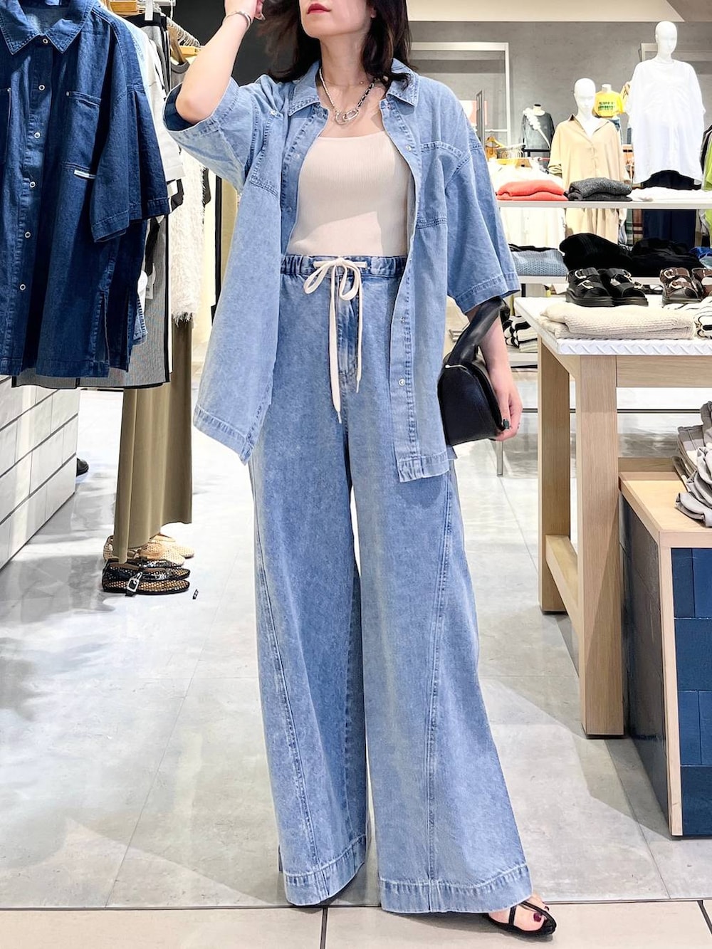 ブルー系のシャツ/ブラウス、ホワイト系のタンクトップ、ブルー系のデニムパンツを着用したレディースの春コーディネートの7枚目の写真