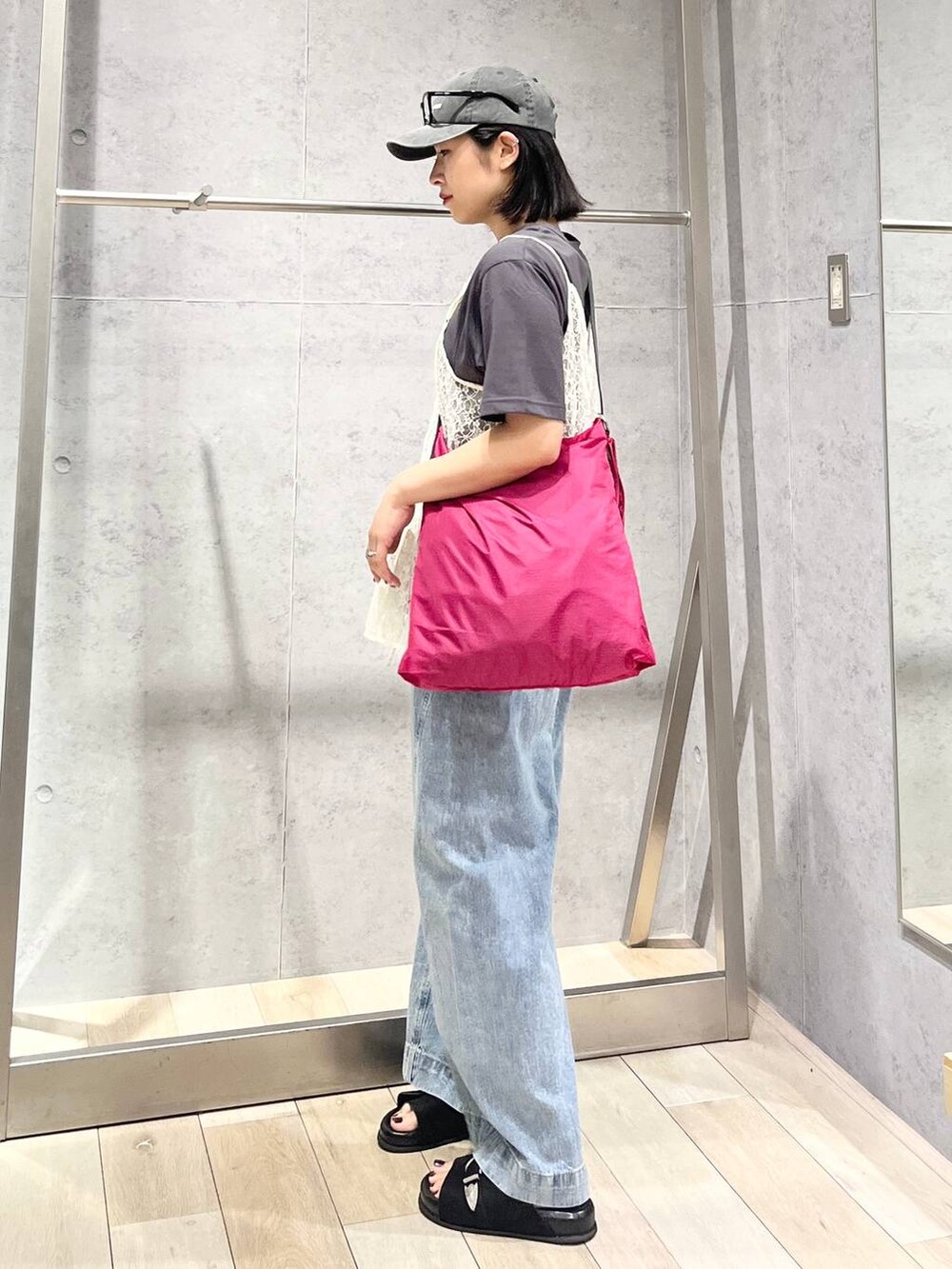 ブルー系のデニムパンツ、ブラック系のサンダル、ピンク系のショルダーバッグを着用したレディースの夏コーディネートの4枚目の写真