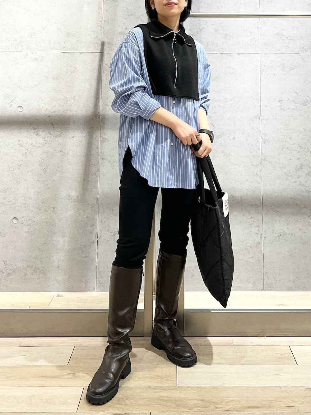 ブラウン系のブーツ、ブラック系のその他パンツ、ブルー系のシャツ/ブラウスを着用したレディースの秋コーディネートの2枚目の写真