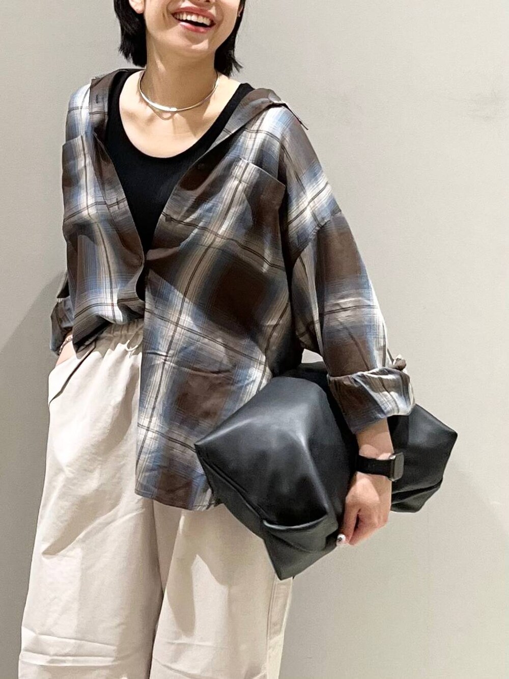 ブラウン系のシャツ/ブラウス、ホワイト系のその他パンツ、ブラック系のハンドバッグを着用したレディースの夏コーディネートの3枚目の写真