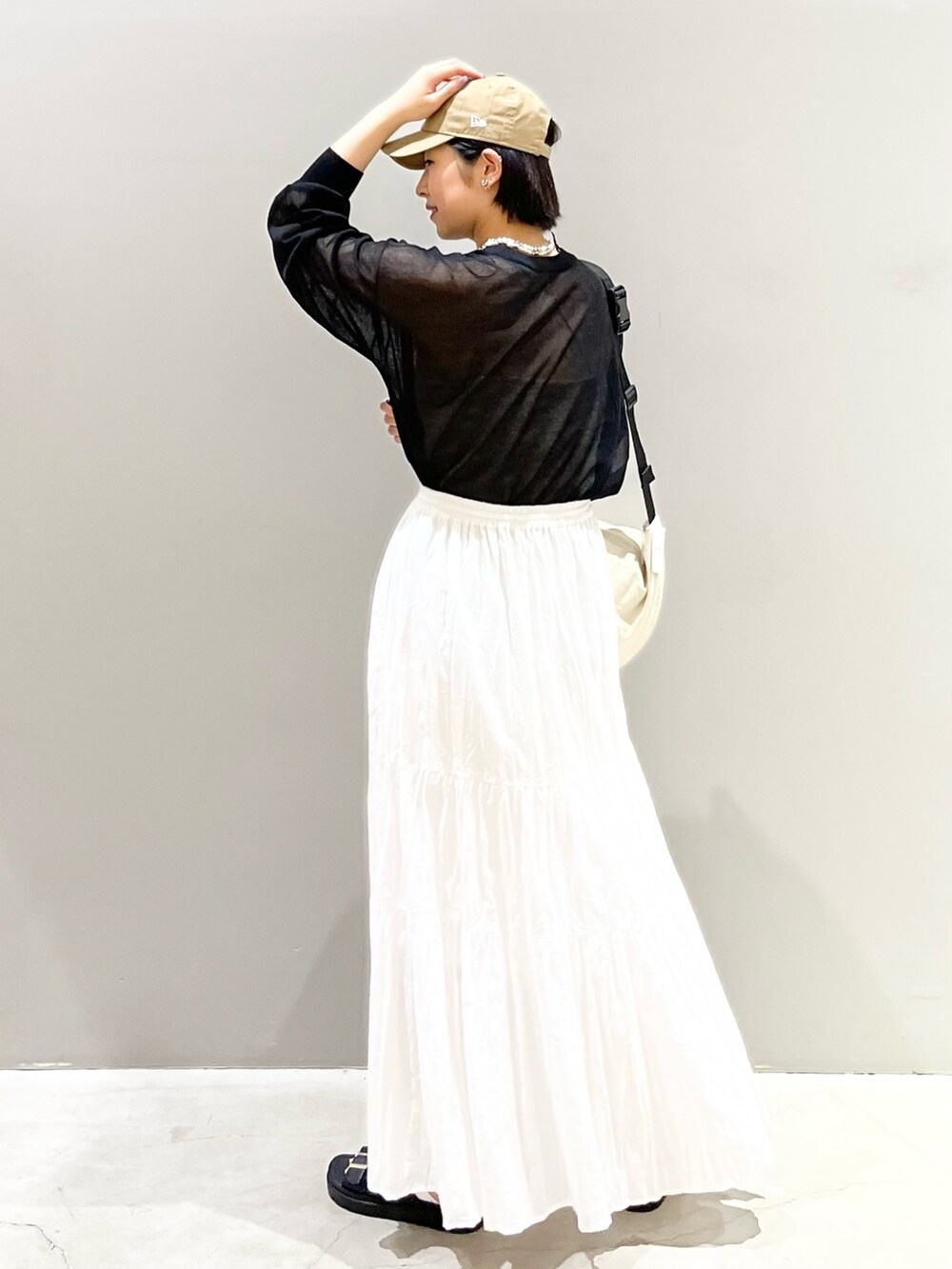 ブラック系のサンダル、ホワイト系のスカート、ホワイト系のショルダーバッグを着用したレディースの夏コーディネートの5枚目の写真