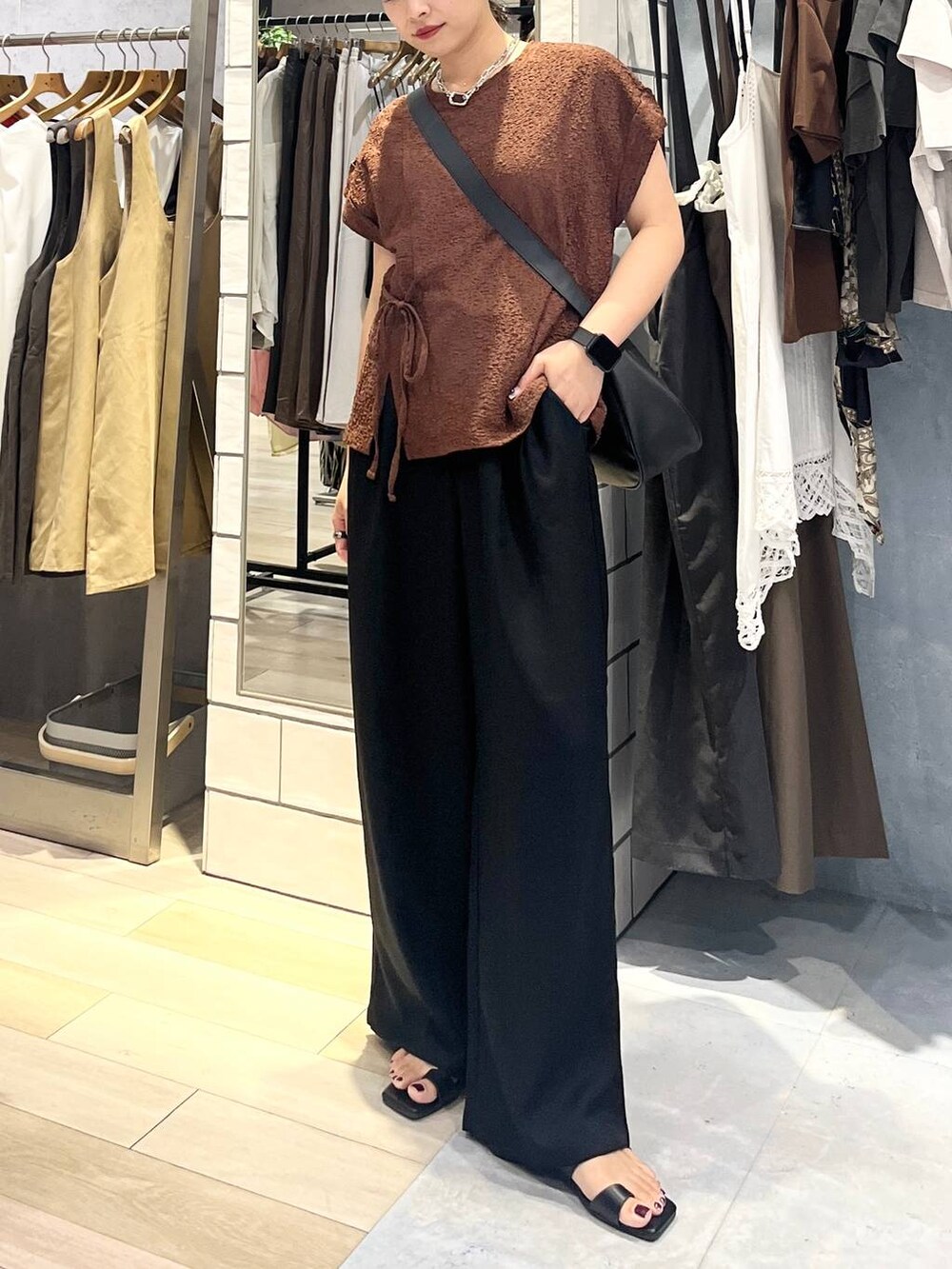 ブラック系のその他パンツ、ブラック系のショルダーバッグ、ブラック系のサンダルを着用したレディースの夏コーディネートの5枚目の写真