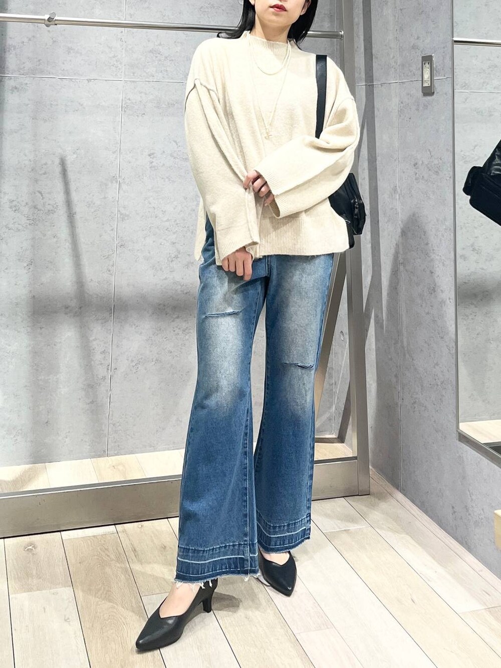 ブラック系のパンプス、ブラック系のショルダーバッグ、ベージュ系のニット/セーターを着用したレディースの冬コーディネートの2枚目の写真