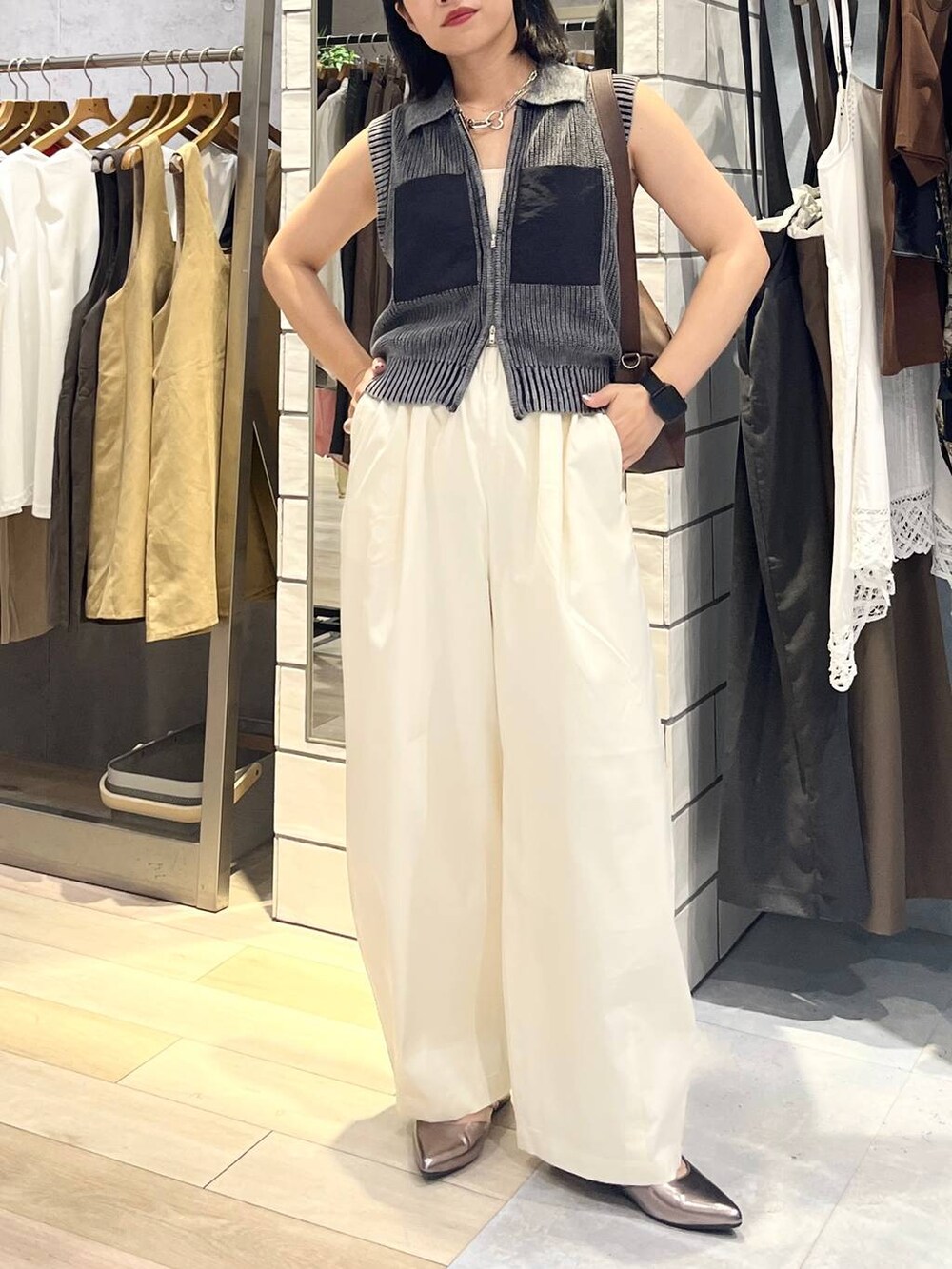 ブラウン系のショルダーバッグ、ホワイト系のタンクトップ、シルバー系のキーホルダーを着用したレディースの夏コーディネートの4枚目の写真