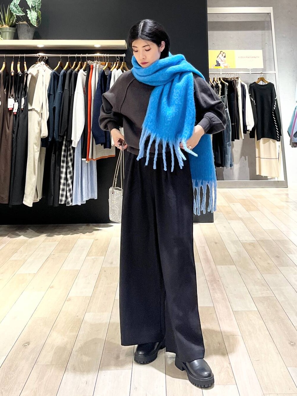 シルバー系のショルダーバッグ、グレー系のニット/セーター、ブラック系のその他パンツを着用したレディースの秋コーディネートの3枚目の写真