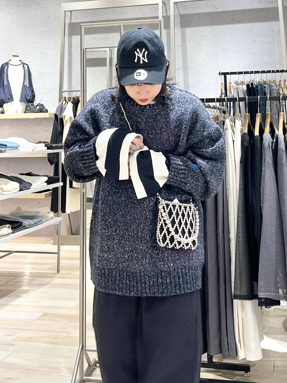 シルバー系のショルダーバッグ、グレー系のチノパンツ、ブラック系のTシャツ/カットソーを着用したレディースの秋コーディネートの2枚目の写真