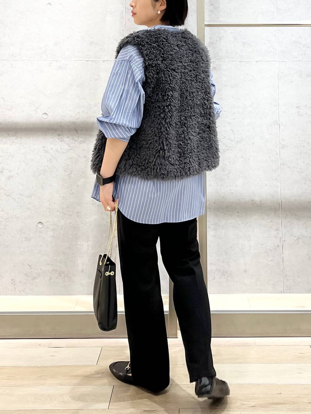 グレー系のベスト、ブラック系のその他パンツ、ブラック系のローファーを着用したレディースの秋コーディネートの5枚目の写真