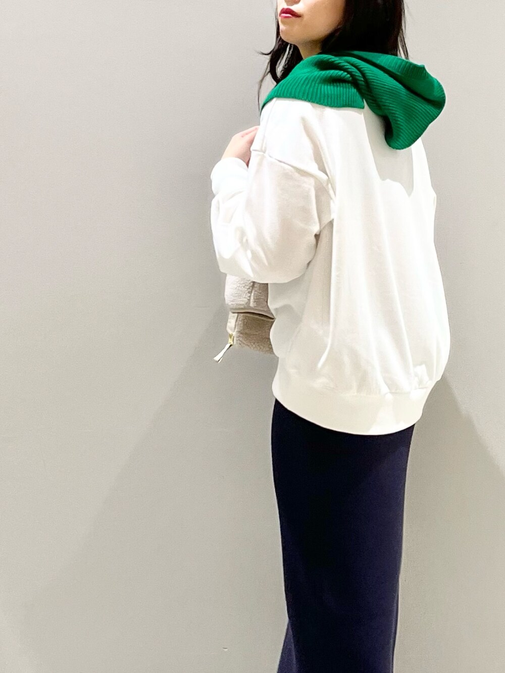 ブルー系のスカート、ブラック系のブーツ、ホワイト系のトップスを着用したレディースの秋コーディネートの5枚目の写真