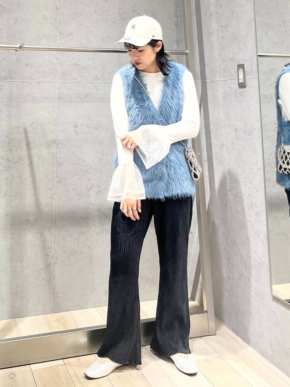 シルバー系のパンプス、ホワイト系のTシャツ/カットソー、ブルー系のベストを着用したレディースの秋コーディネートの6枚目の写真