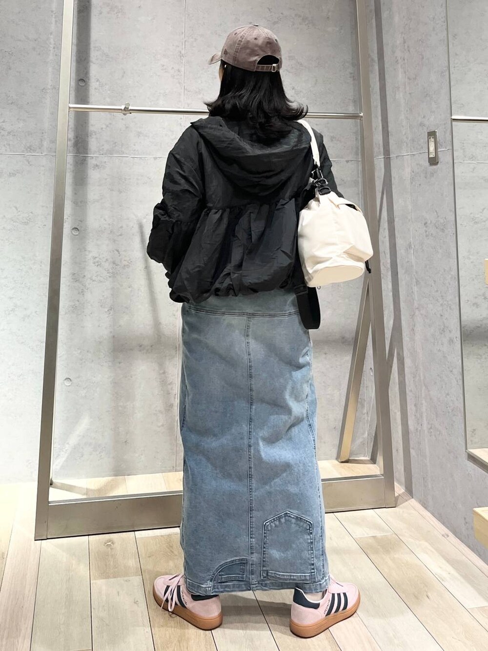 ホワイト系のショルダーバッグ、ブルー系のデニムスカート、ブラウン系のキャップを着用したレディースの冬コーディネートの7枚目の写真