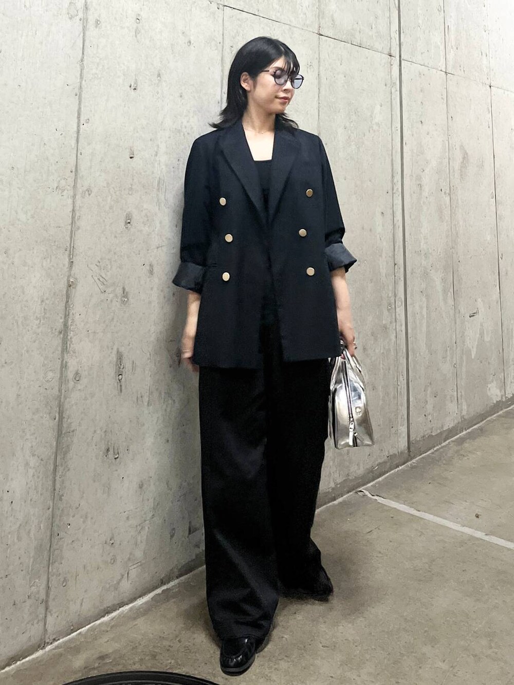 ブルー系のテーラードジャケット、シルバー系のボストンバッグ、グレー系のチノパンツを着用したレディースの秋コーディネートの6枚目の写真