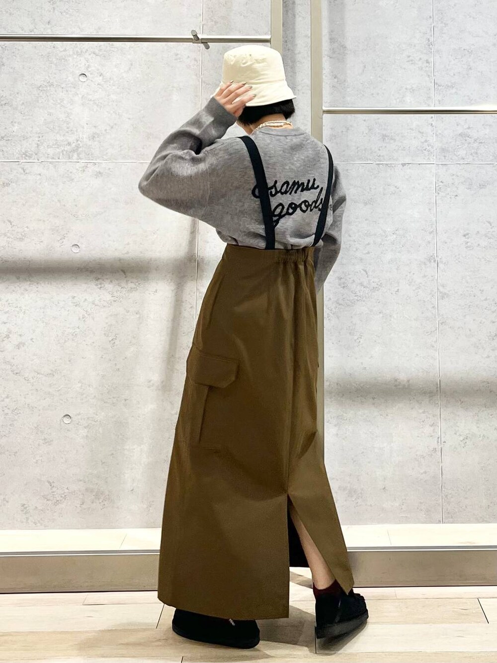 ブラック系のモカシン/デッキシューズ、ブラウン系のスカート、グレー系のニット/セーターを着用したレディースの冬コーディネートの6枚目の写真