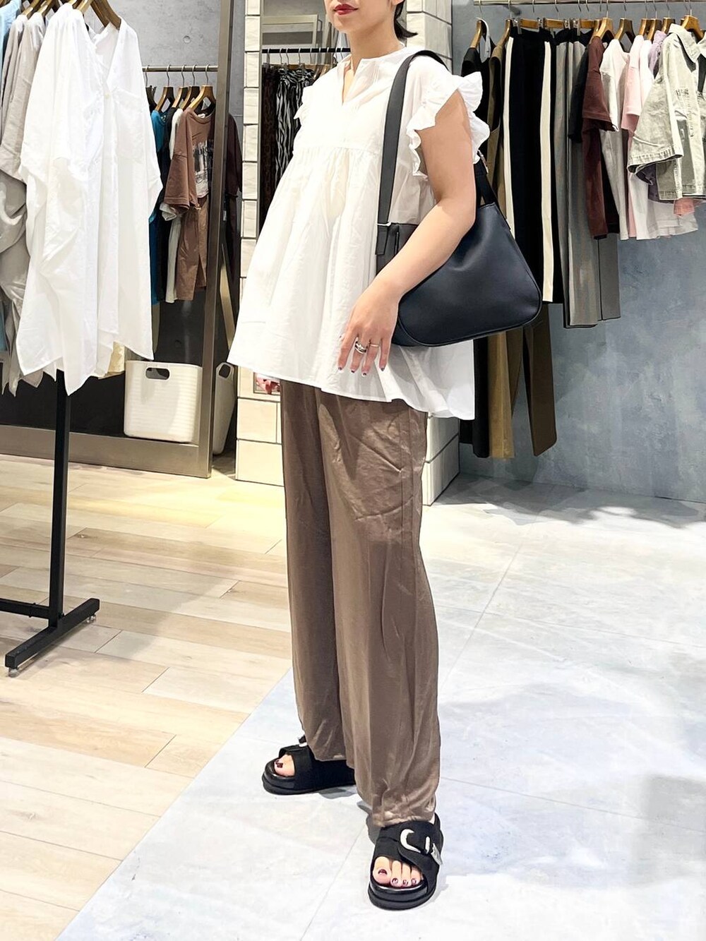 ブラック系のサンダル、ブラウン系のその他パンツ、ブラック系のショルダーバッグを着用したレディースの夏コーディネートの5枚目の写真