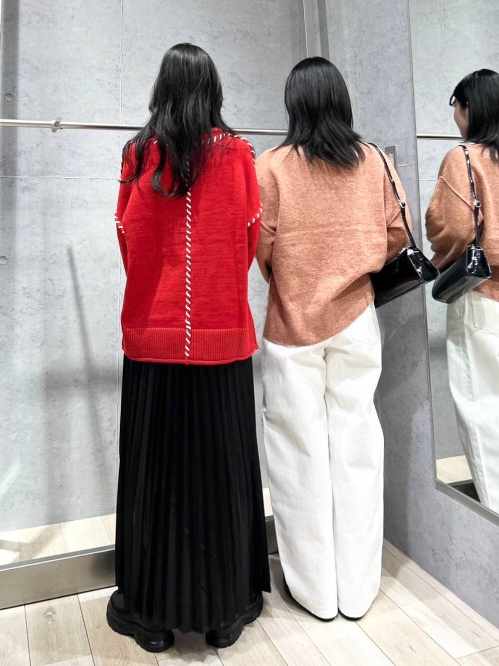 シルバー系のショルダーバッグ、ブラック系のブーツ、ホワイト系のデニムパンツを着用したレディースの冬コーディネートの4枚目の写真