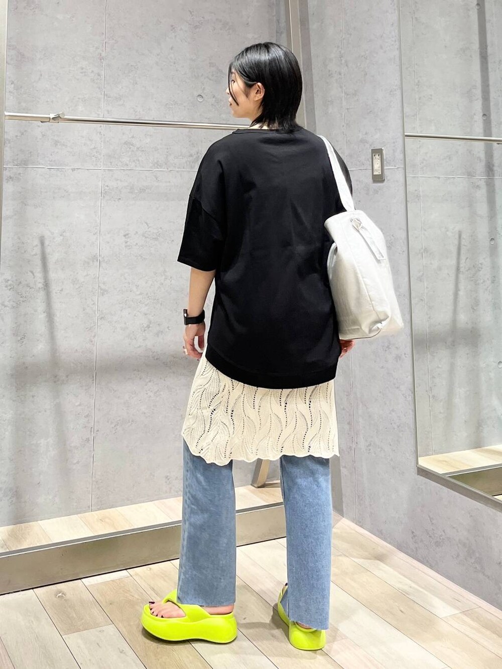 イエロー系のサンダル、グレー系のショルダーバッグ、ブルー系のデニムパンツを着用したレディースの春コーディネートの8枚目の写真