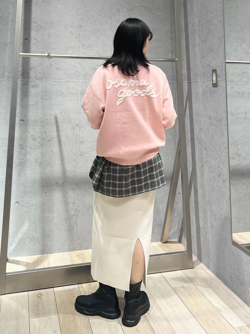 シルバー系のショルダーバッグ、ホワイト系のスカート、ブラック系のブーツを着用したレディースの冬コーディネートの5枚目の写真