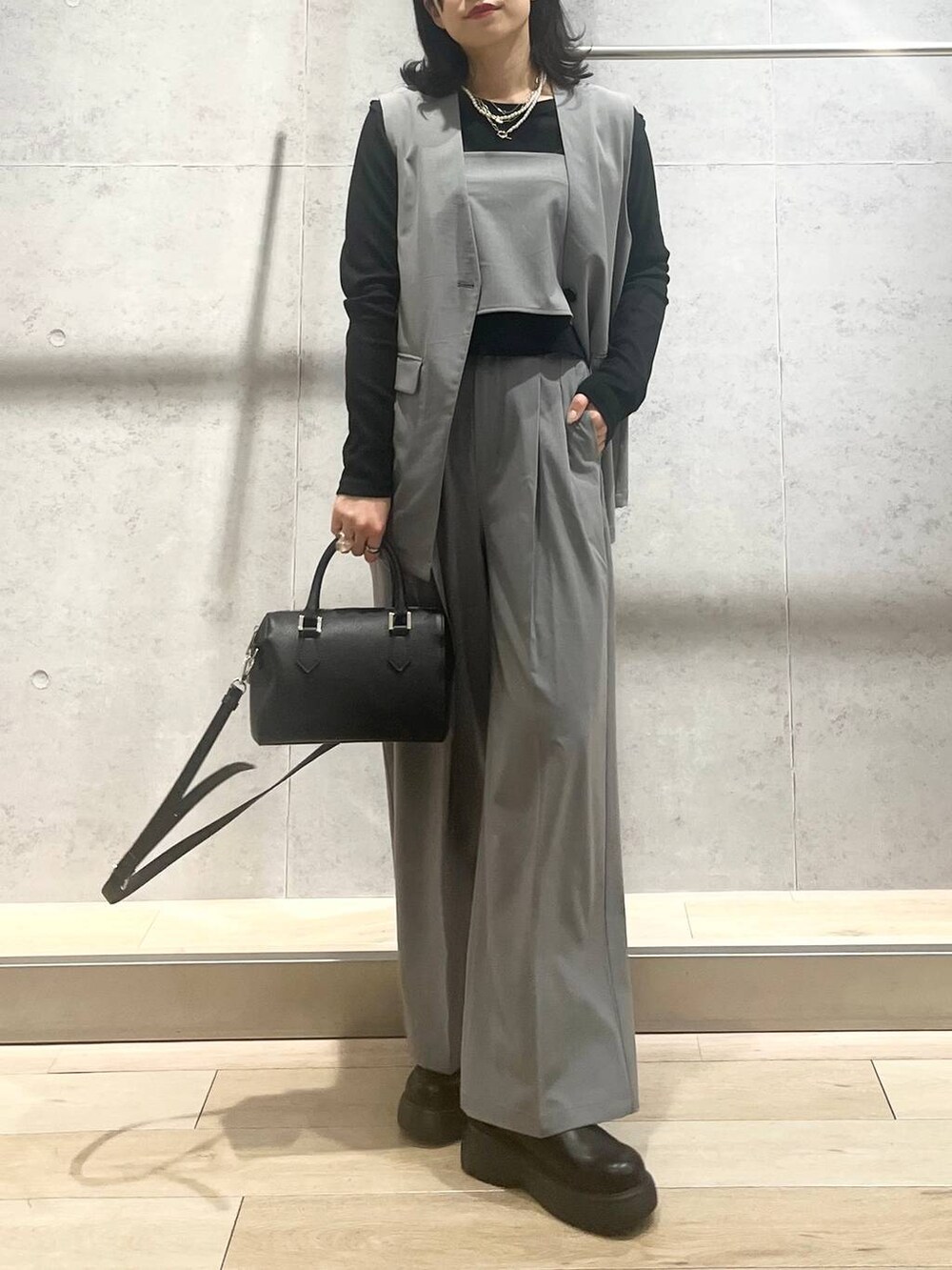 ブラック系のボストンバッグ、グレー系のその他パンツ、ブラック系のサンダルを着用したレディースの春コーディネートの3枚目の写真