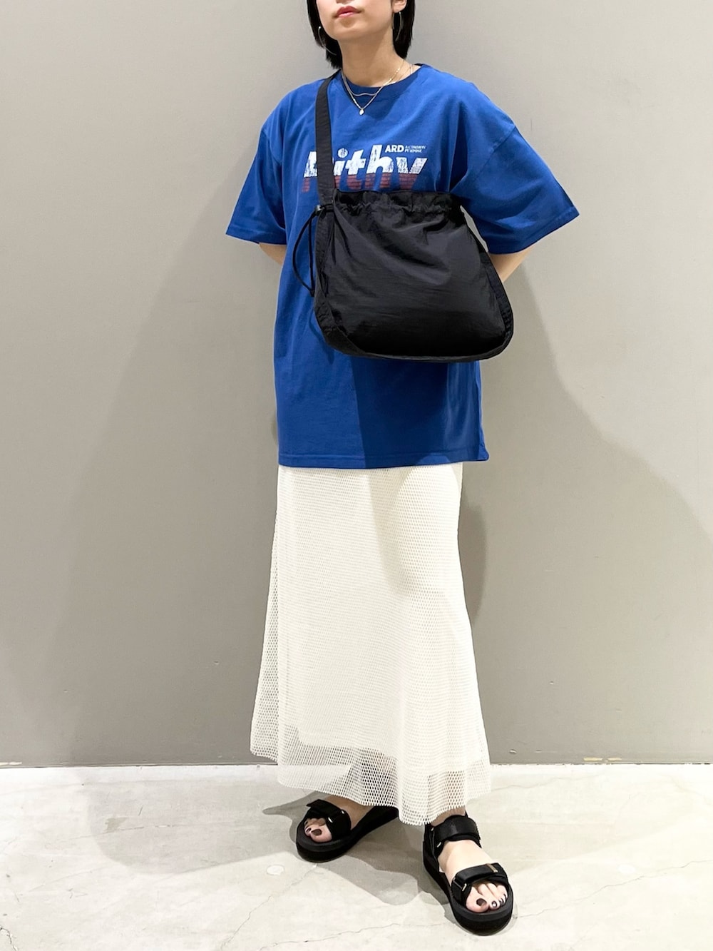 ホワイト系のスカート、ブラック系のサンダル、ブラック系のショルダーバッグを着用したレディースの夏コーディネートの3枚目の写真