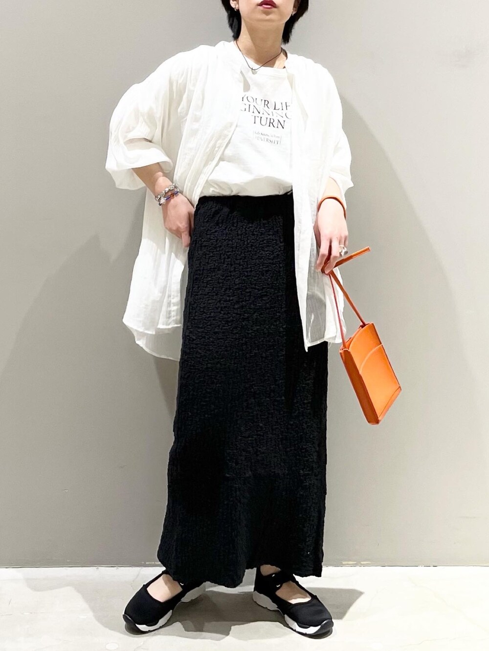 ホワイト系のTシャツ/カットソー、ホワイト系のシャツ/ブラウス、ブラック系のスカートを着用したレディースの春コーディネートの2枚目の写真