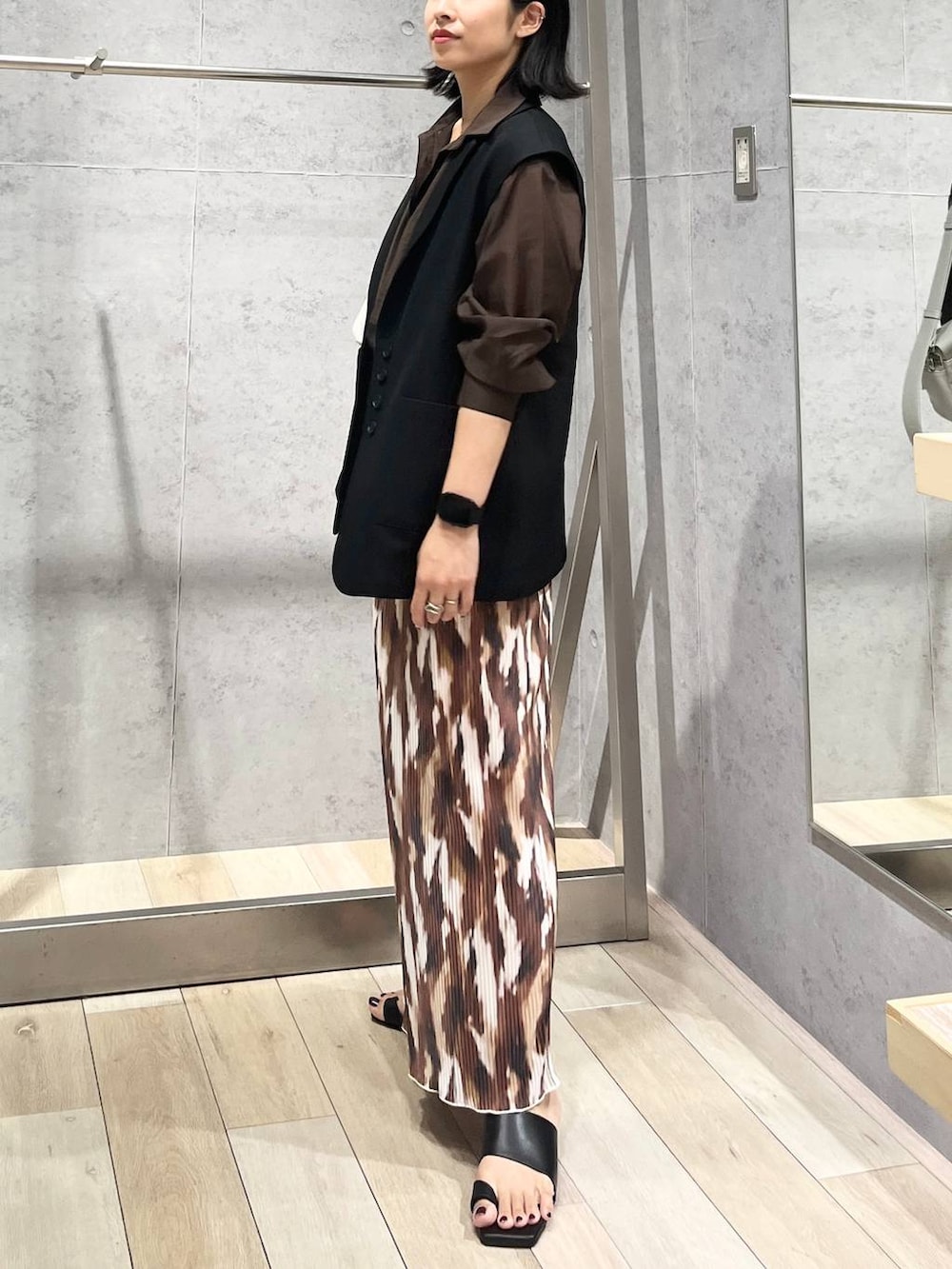 ブラウン系のシャツ/ブラウス、ブラック系のサンダル、グレー系のショルダーバッグを着用したレディースの秋コーディネートの2枚目の写真