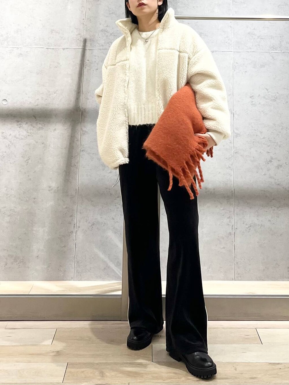 ブラック系のブーツ、ホワイト系のニット/セーター、ホワイト系のその他アウターを着用したレディースの冬コーディネートの2枚目の写真