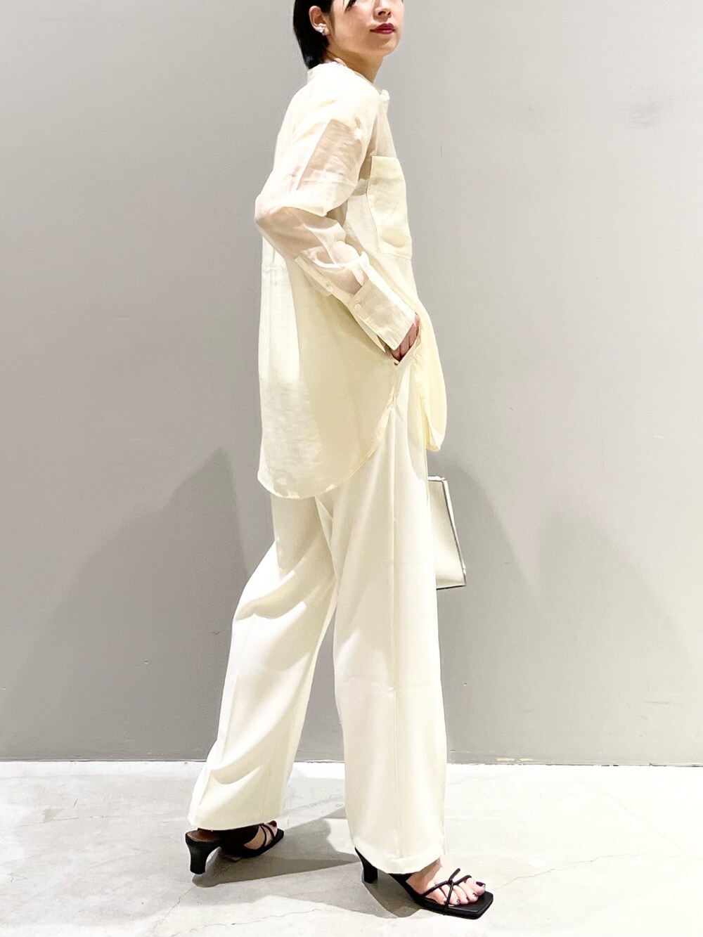 ホワイト系のシャツ/ブラウス、ホワイト系のスラックス、ホワイト系のショルダーバッグを着用したレディースの夏コーディネートの3枚目の写真