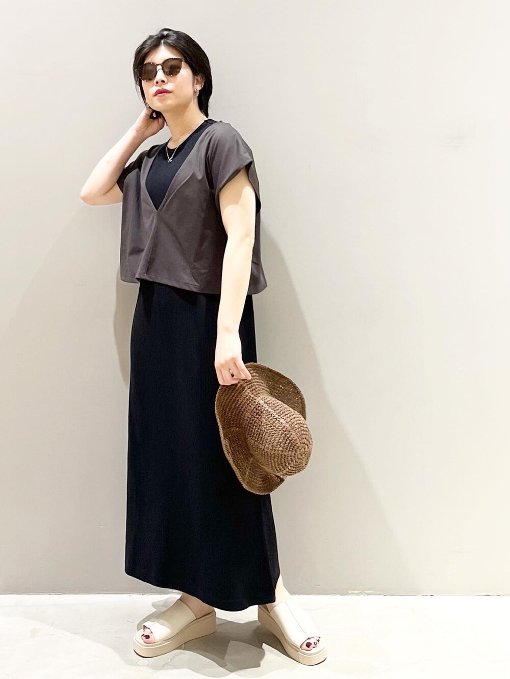 ベージュ系のサンダル、ブラック系のワンピース、ブラウン系のハットを着用したレディースの春コーディネートの4枚目の写真