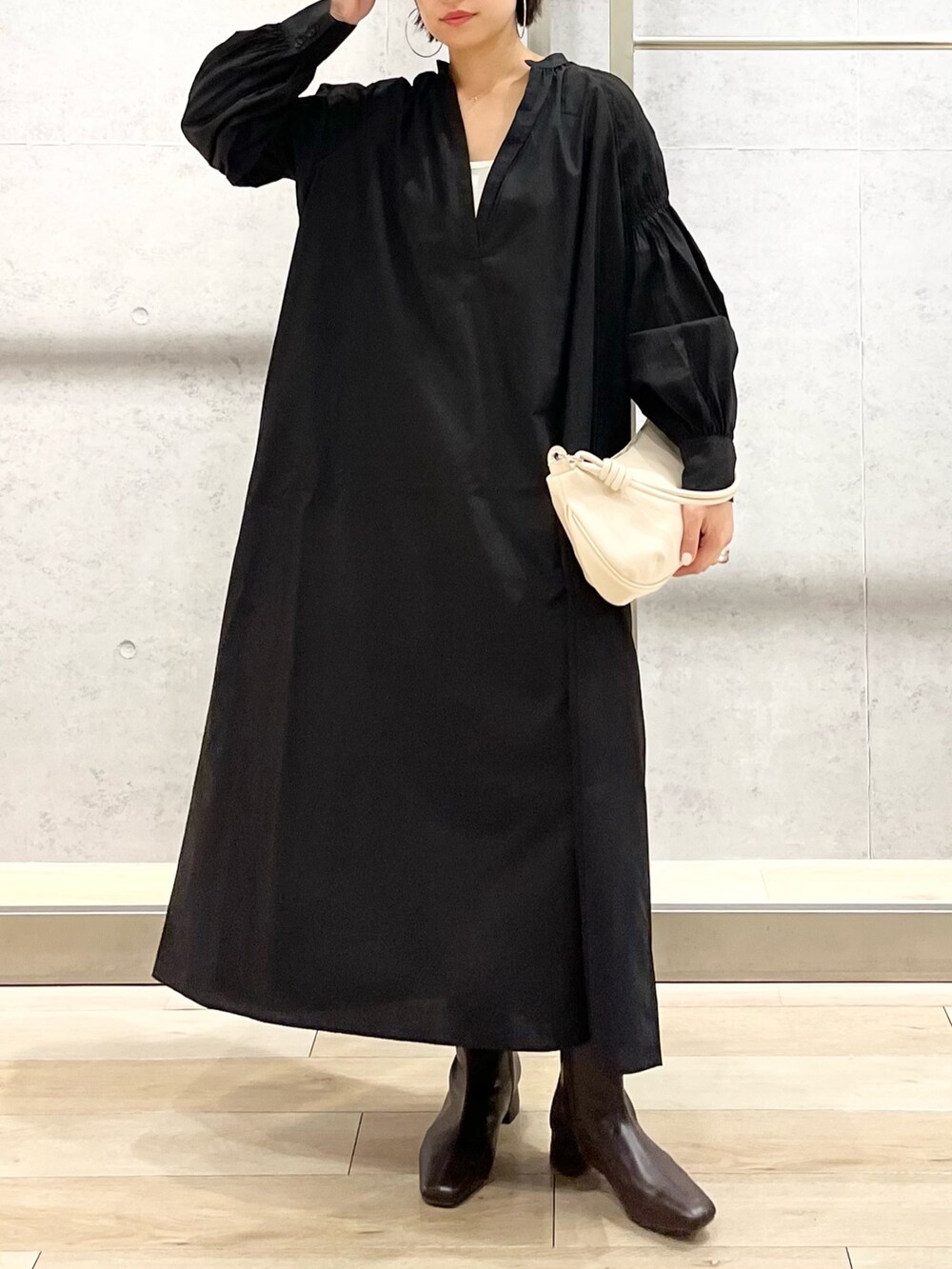 ブラック系のワンピース/ドレス、ブラウン系のブーツ、ホワイト系のショルダーバッグを着用したレディースの秋コーディネートの7枚目の写真