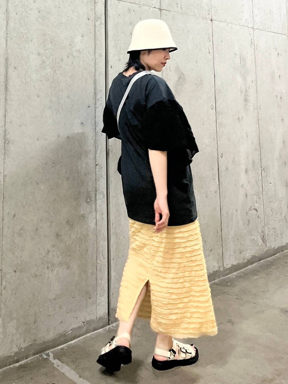 ベージュ系のスカート、シルバー系のショルダーバッグ、ホワイト系のサンダルを着用したレディースの春コーディネートの5枚目の写真