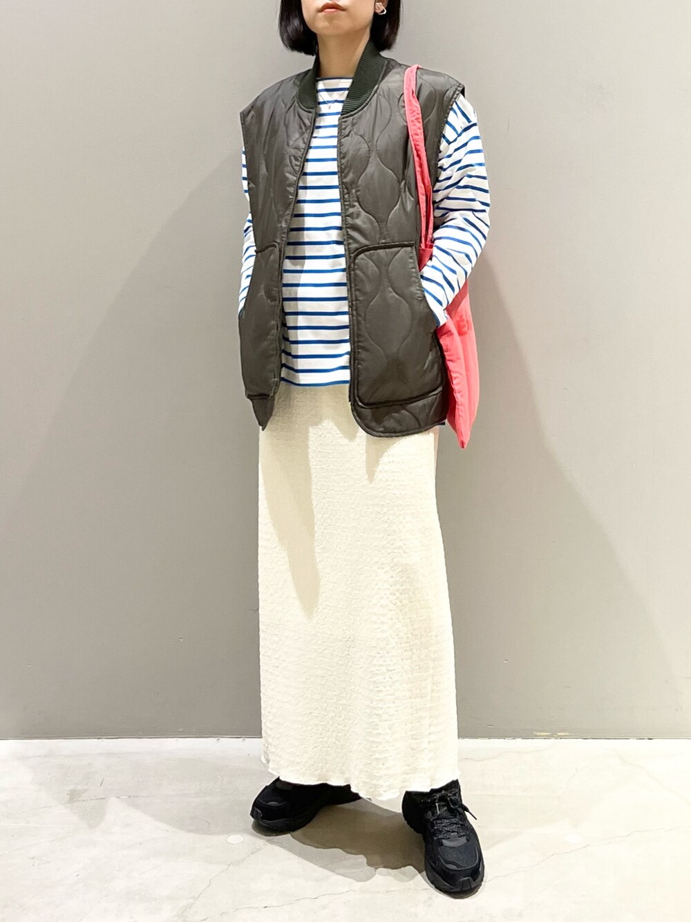 ピンク系のトートバッグ、ブラック系のスニーカー、ブルー系のTシャツ/カットソーを着用したレディースの春コーディネートの2枚目の写真