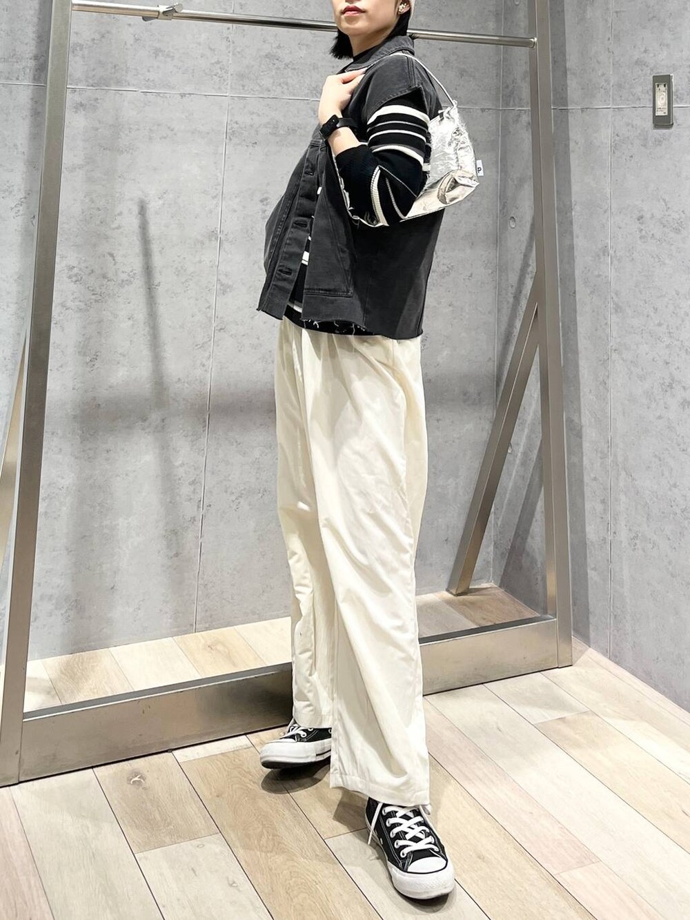 シルバー系のハンドバッグ、グレー系のベスト、ホワイト系のその他パンツを着用したレディースの冬コーディネートの5枚目の写真