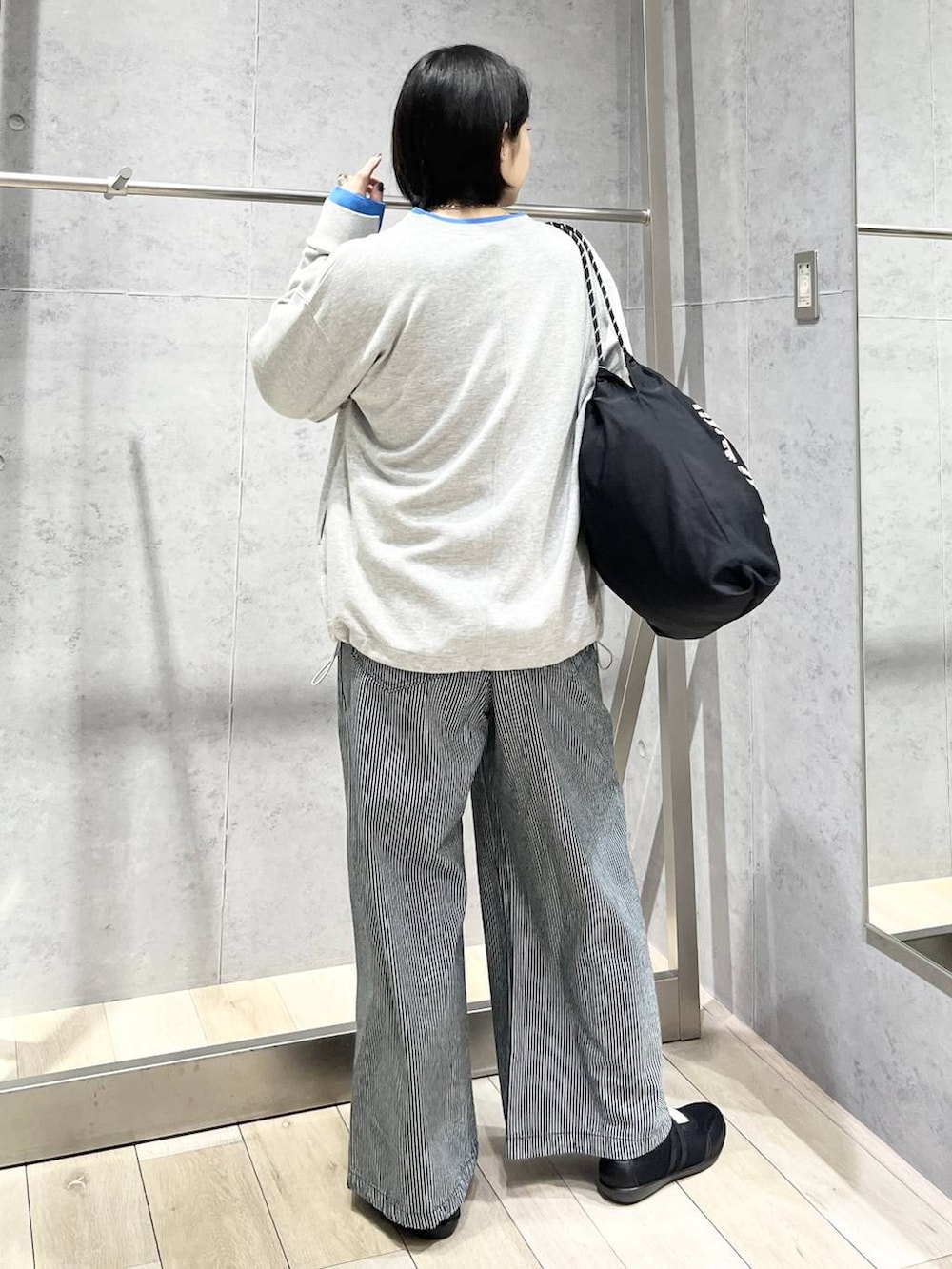 ブラック系のパンプス、ブラック系のトートバッグ、グレー系のTシャツ/カットソーを着用したレディースの冬コーディネートの5枚目の写真