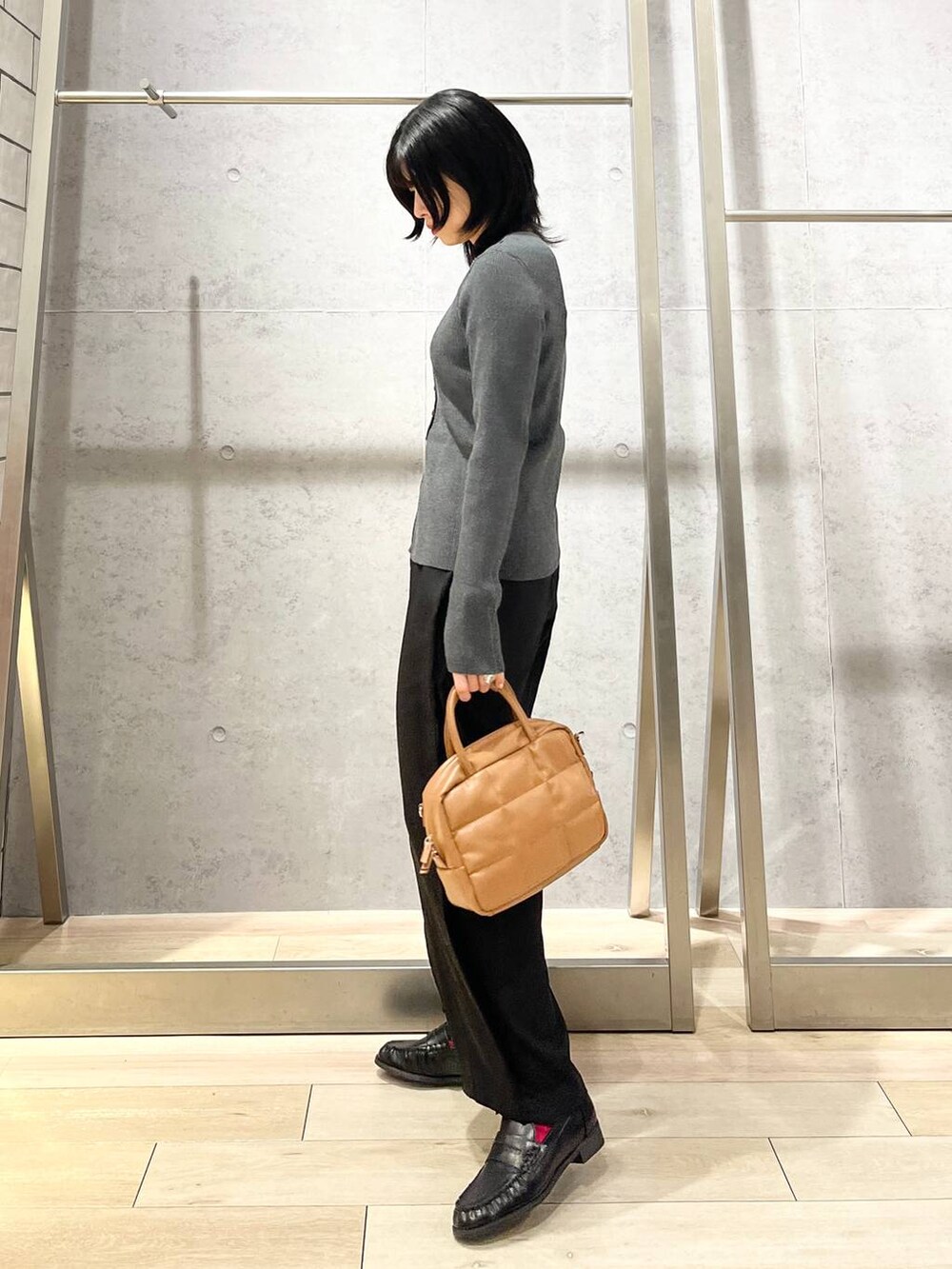 ブラック系のローファー、ブラウン系のボストンバッグ、ブラック系のその他パンツを着用したレディースの秋コーディネートの4枚目の写真