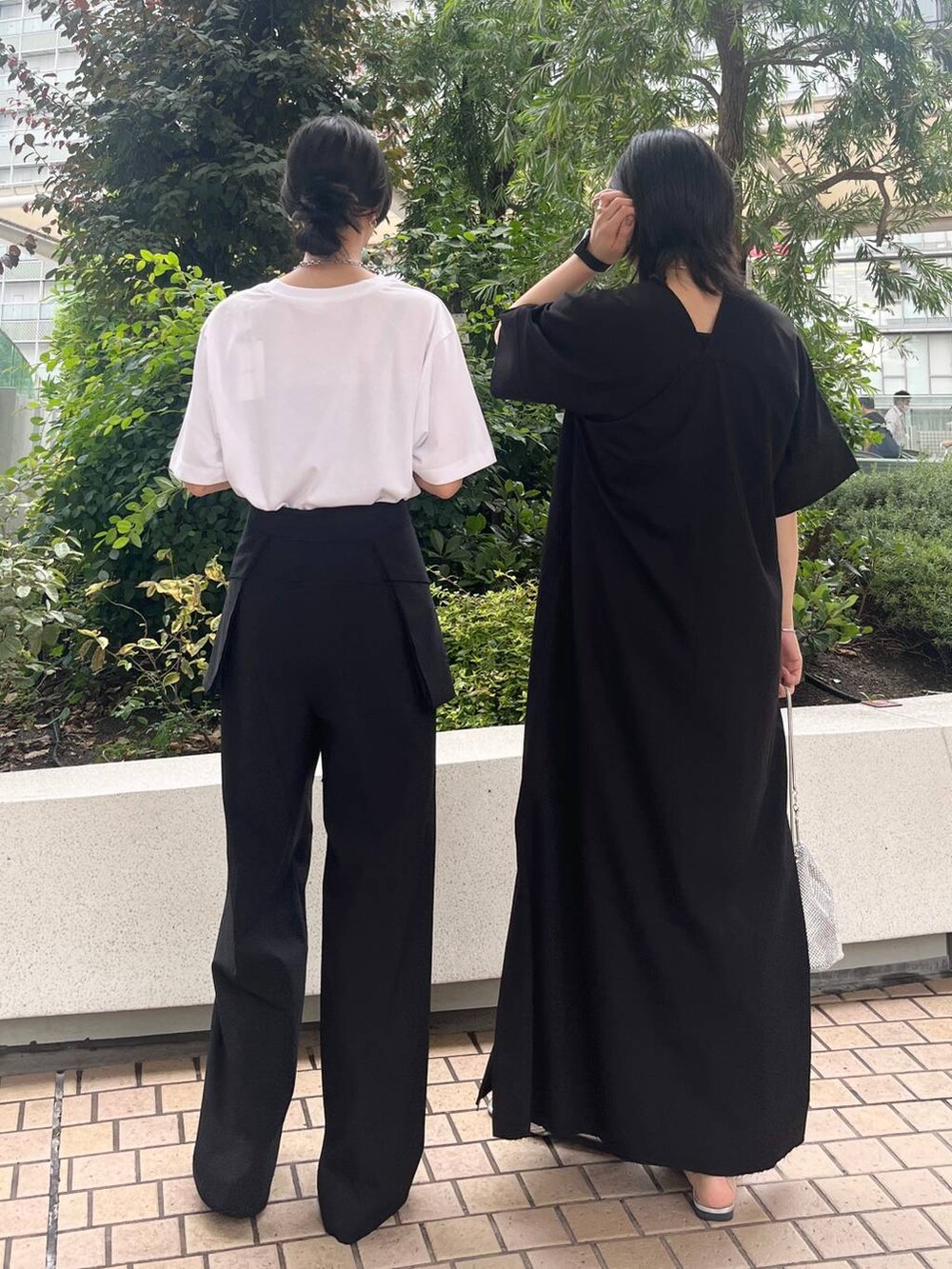 シルバー系のショルダーバッグ、ブラック系のサンダル、ブラック系のワンピースを着用したレディースの夏コーディネートの4枚目の写真