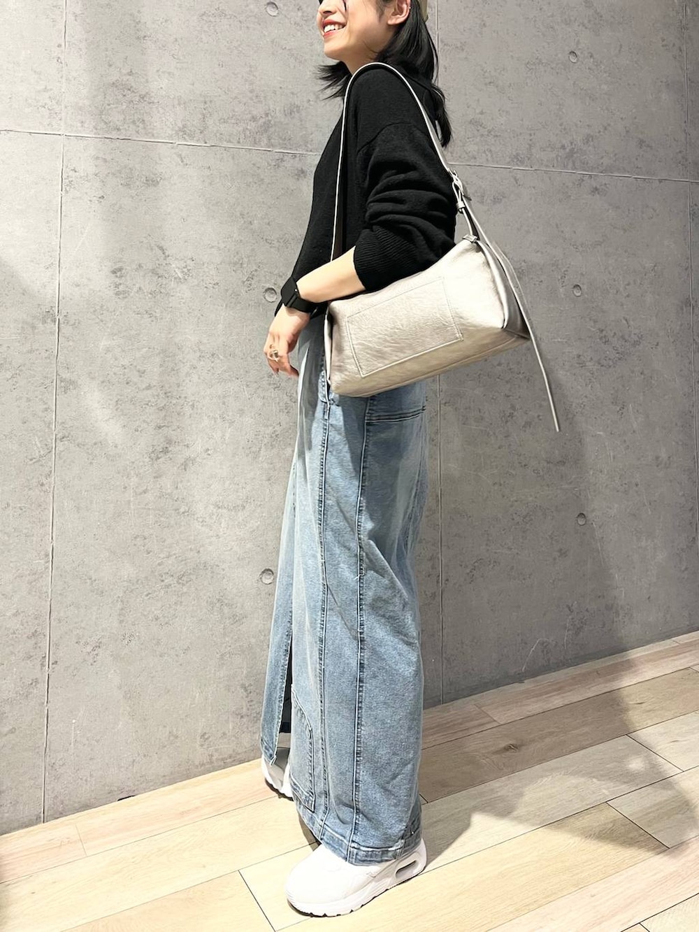 グレー系のTシャツ/カットソー、ブルー系のデニムスカート、ブラック系のニット/セーターを着用したレディースの冬コーディネートの7枚目の写真