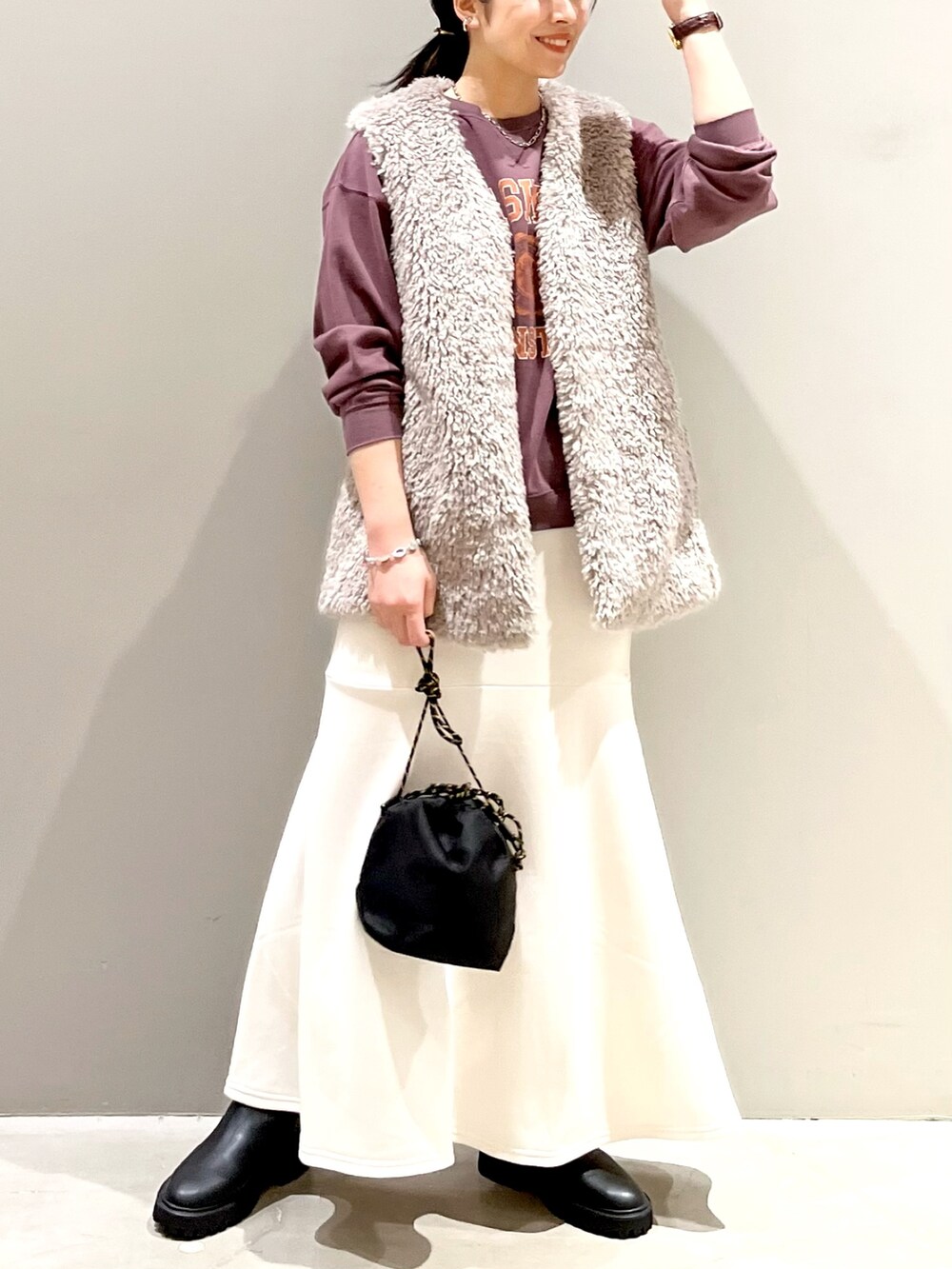ホワイト系のスカート、ブラック系のブーツ、ブラック系のショルダーバッグを着用したレディースの秋コーディネートの4枚目の写真