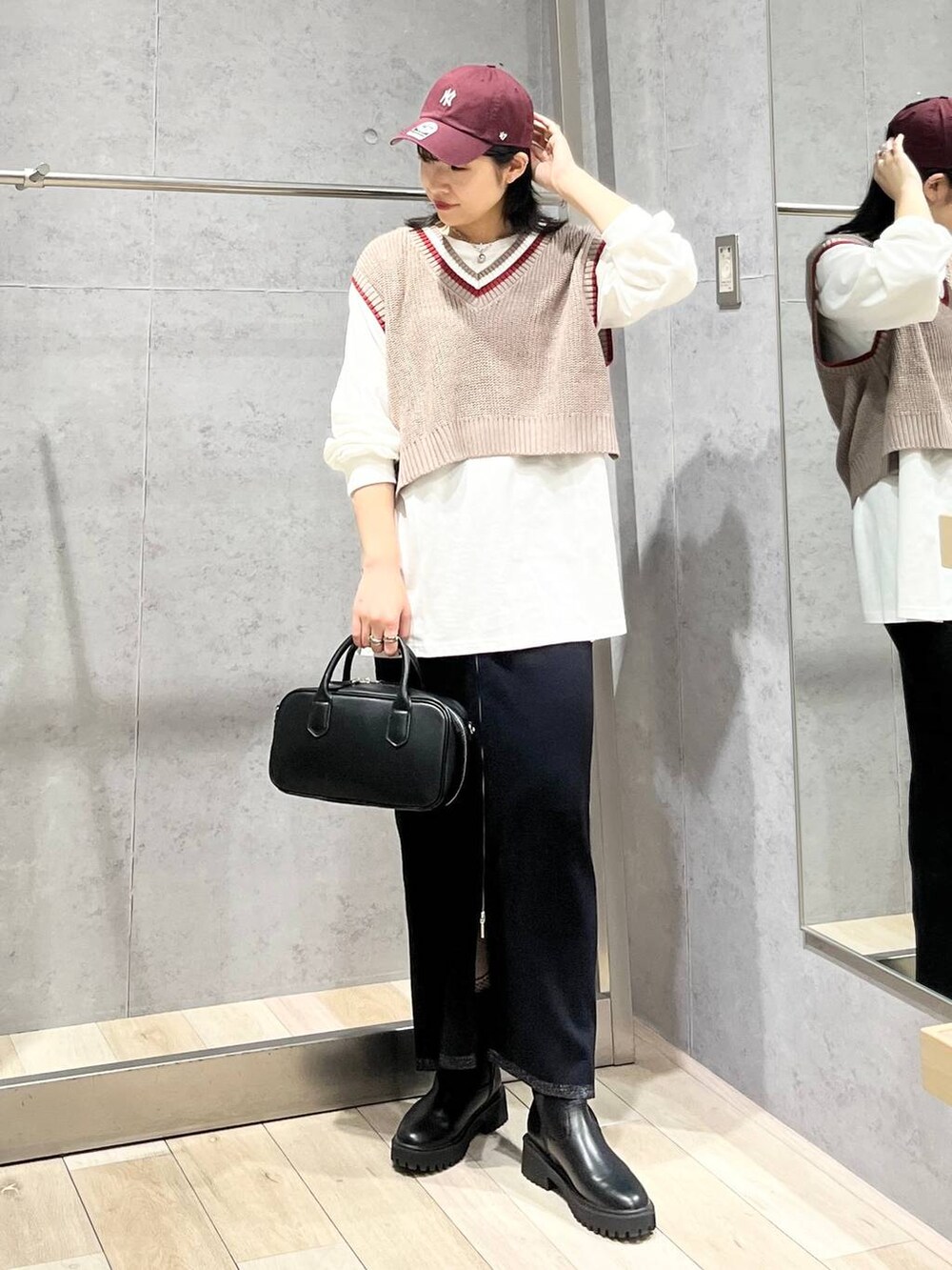 ブラック系のボストンバッグ、ブラック系のブーツ、ブラック系のスカートを着用したレディースの秋コーディネートの7枚目の写真