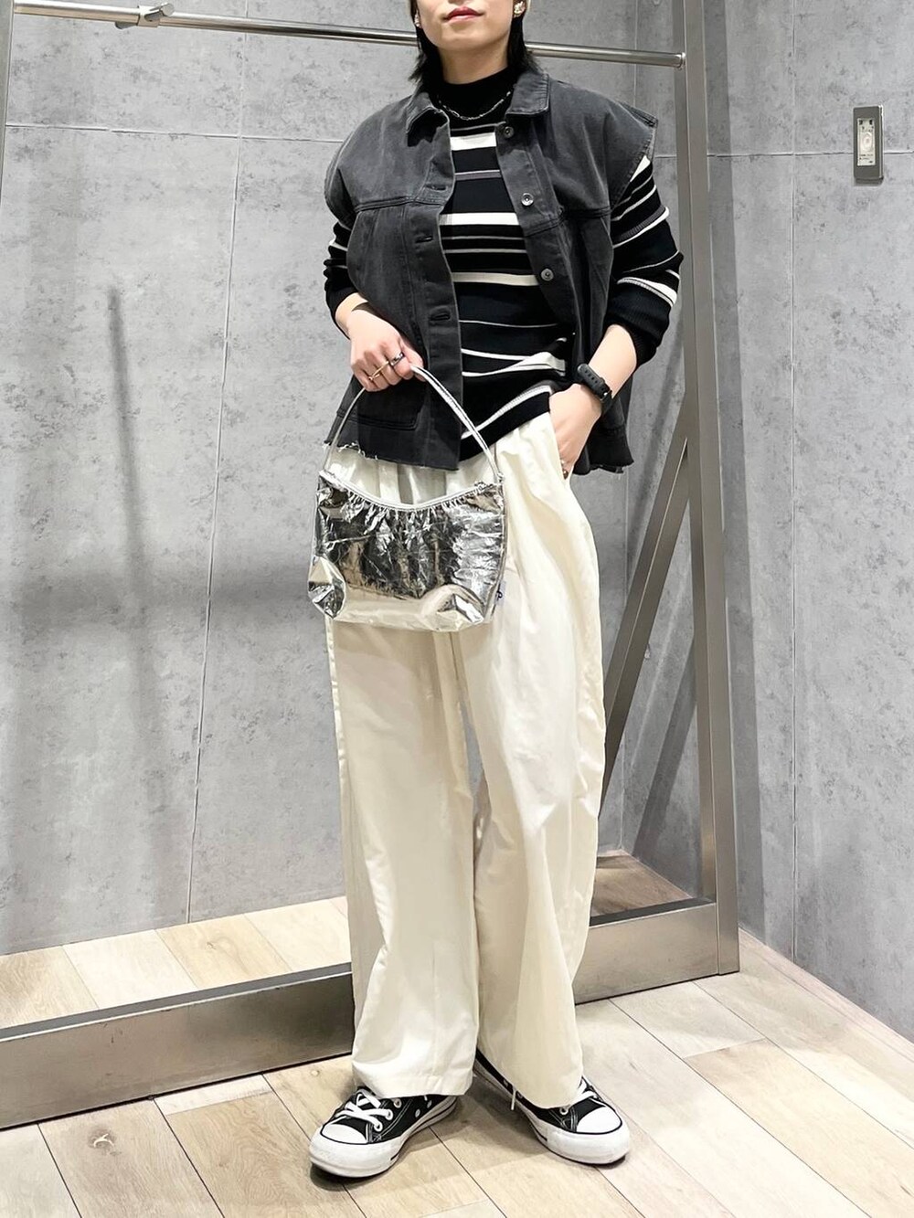 シルバー系のハンドバッグ、グレー系のベスト、ホワイト系のその他パンツを着用したレディースの冬コーディネートの7枚目の写真