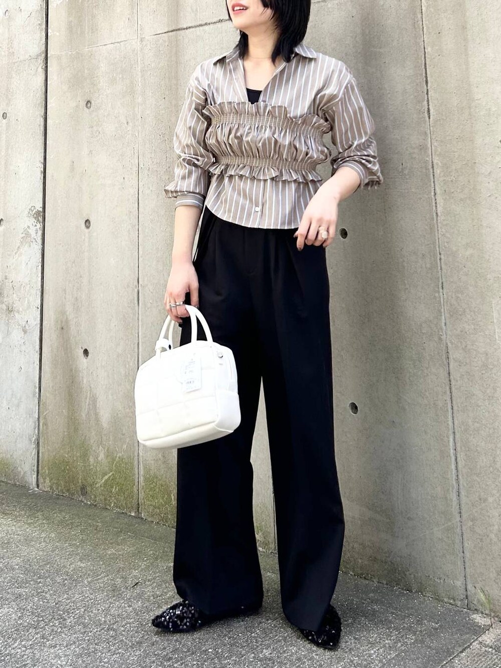 ブラック系のパンプス、ブラック系のその他パンツ、ホワイト系のボストンバッグを着用したレディースの秋コーディネートの4枚目の写真