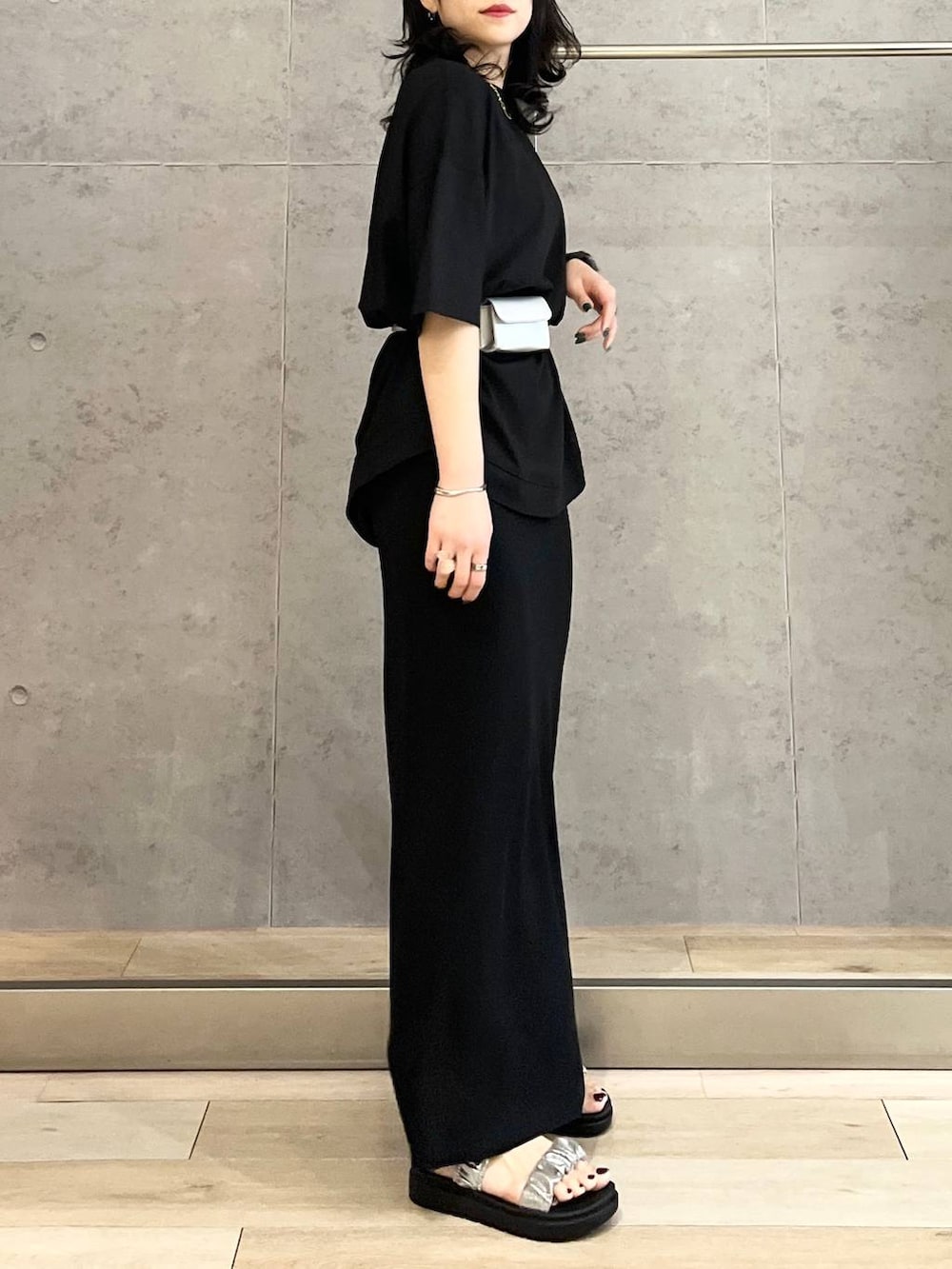 ブラック系のスカート、ブラック系のTシャツ/カットソー、シルバー系のサンダルを着用したレディースの春コーディネートの5枚目の写真