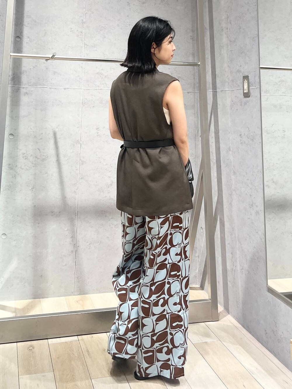 ホワイト系のタンクトップ、ホワイト系のサンダル、ブラック系のハンドバッグを着用したレディースの夏コーディネートの4枚目の写真