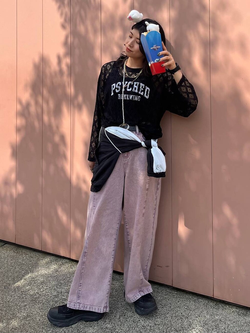 パープル系のデニムパンツ、ブラック系のTシャツ/カットソー、ホワイト系のネックレスを着用したレディースの春コーディネートの3枚目の写真