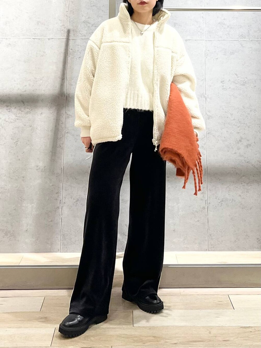 ブラック系のブーツ、ホワイト系のニット/セーター、ホワイト系のその他アウターを着用したレディースの冬コーディネートの5枚目の写真