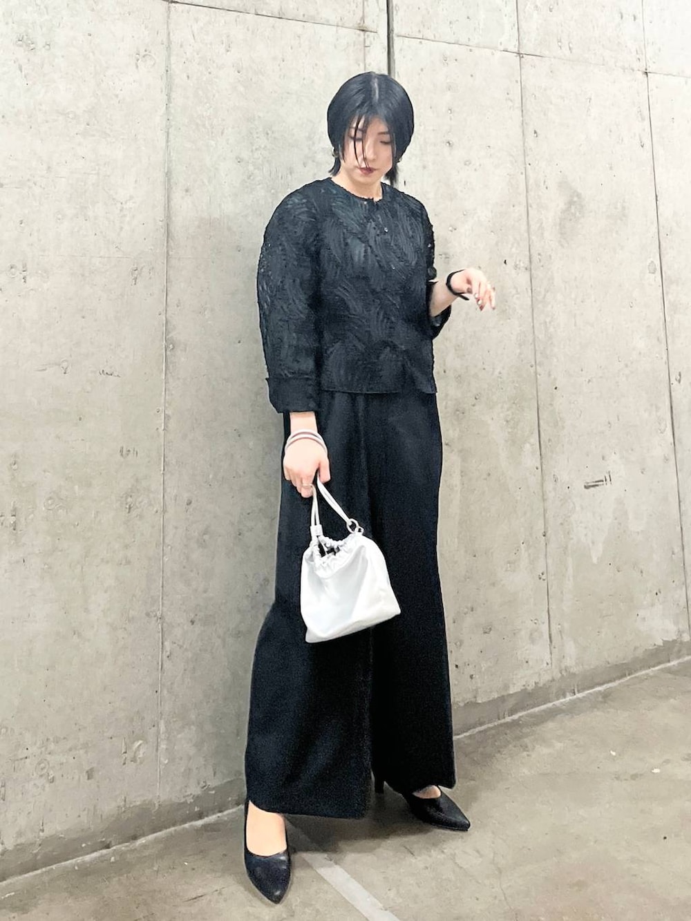 シルバー系のショルダーバッグ、ブラック系のシャツ/ブラウス、ブラック系のパンプスを着用したレディースの春コーディネートの2枚目の写真