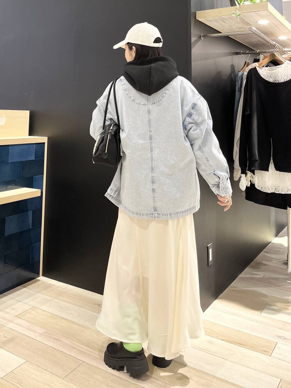 ブラック系のパーカー、ブルー系のシャツ/ブラウス、ブラック系のボストンバッグを着用したレディースの春コーディネートの4枚目の写真