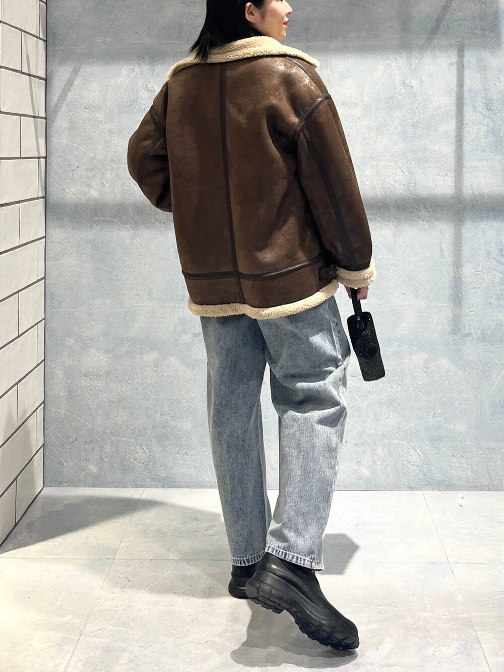 ブラウン系のその他アウター、ブラック系のブーツ、グレー系のニット/セーターを着用したレディースの秋コーディネートの4枚目の写真