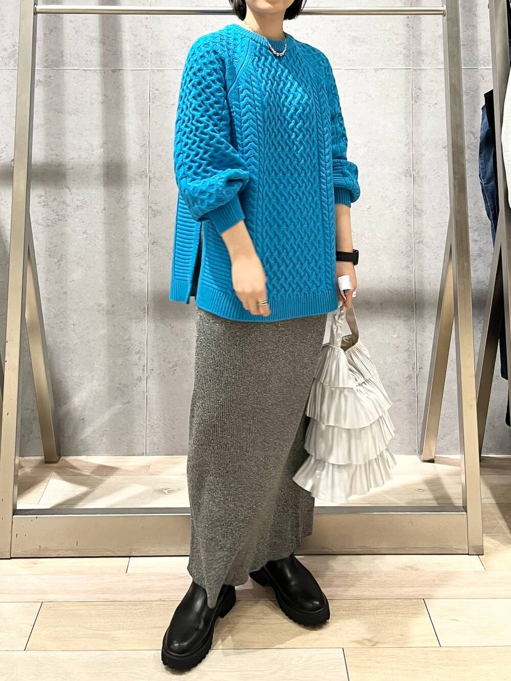 ブラック系のブーツ、シルバー系のトートバッグ、ブルー系のその他トップスを着用したレディースの秋コーディネートの6枚目の写真