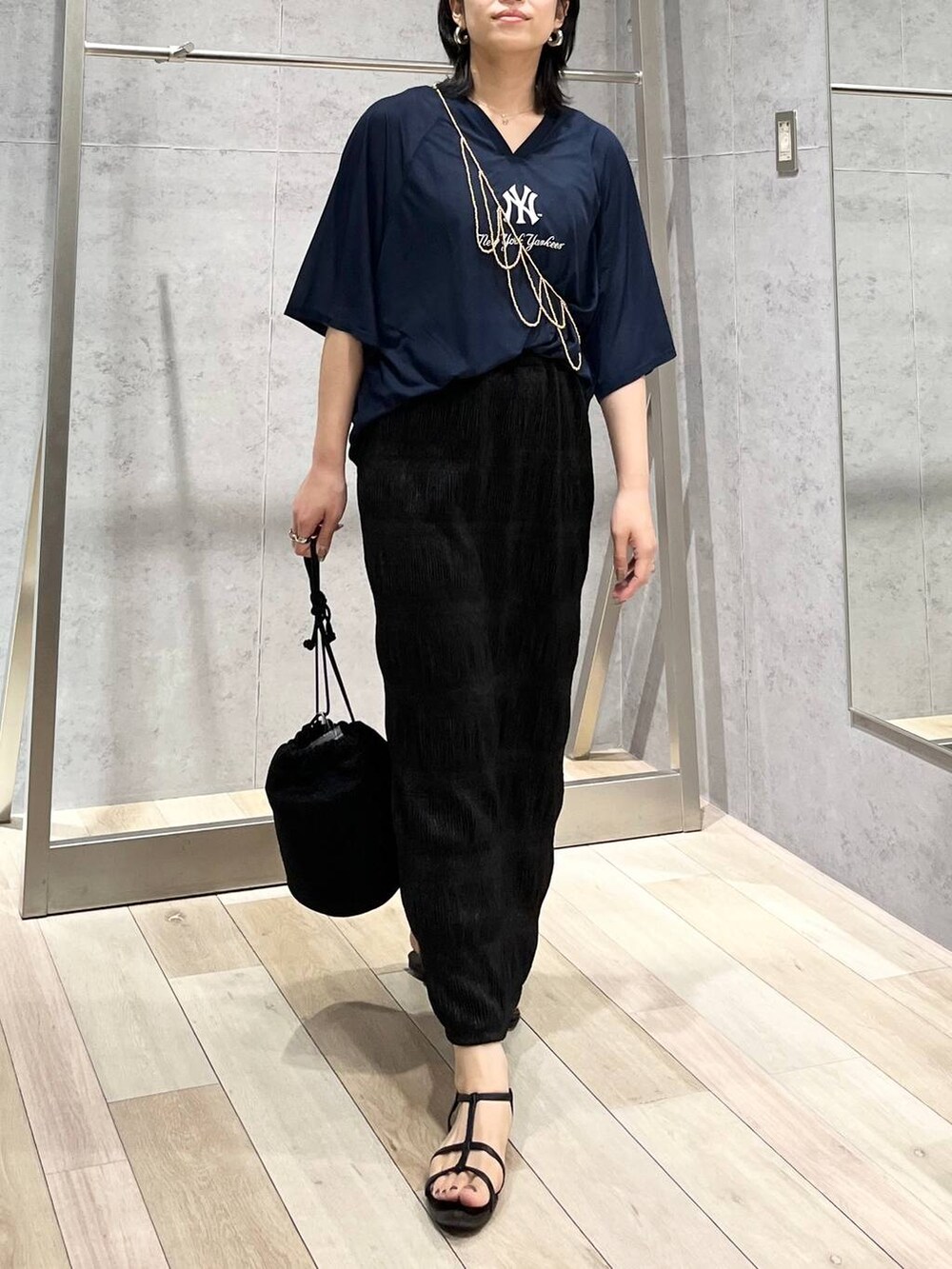 ブラック系のサンダル、ブラック系のスカート、ホワイト系のTシャツ/カットソーを着用したレディースの夏コーディネートの2枚目の写真