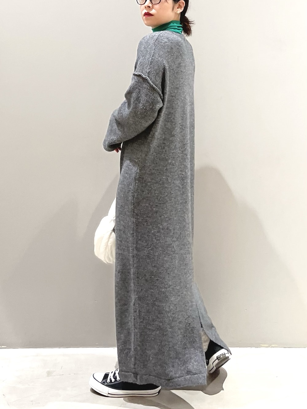 ブラック系のスニーカー、ホワイト系のバッグ、グレー系のワンピース/ドレスを着用したレディースの秋コーディネートの2枚目の写真