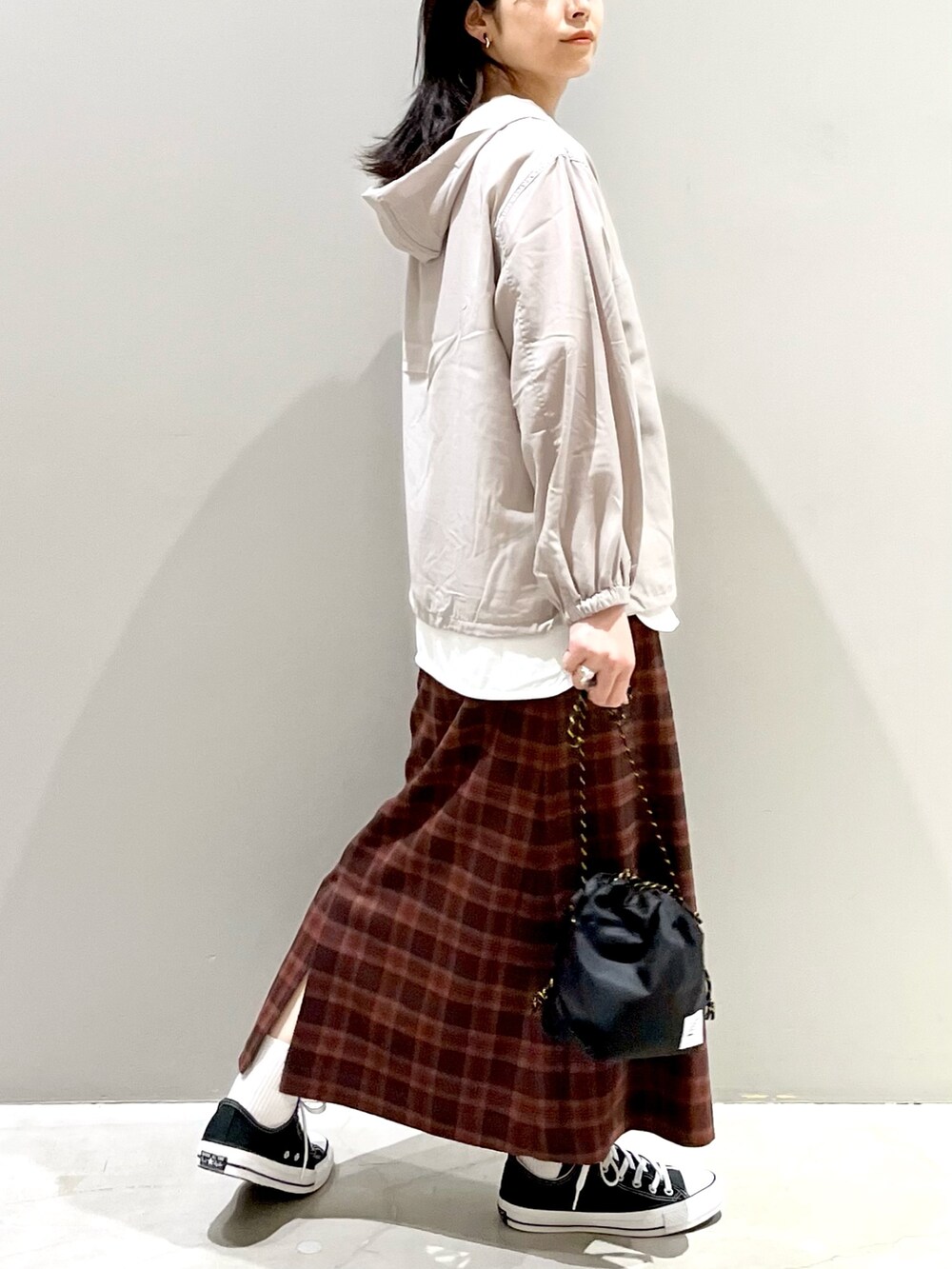 ブラック系のショルダーバッグ、ブラック系のスニーカー、グレー系のトップスを着用したレディースの冬コーディネートの3枚目の写真